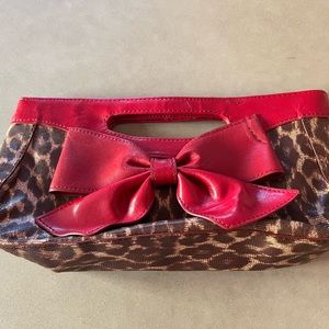Isabelle Fiore leopard clutch with red bow trim.